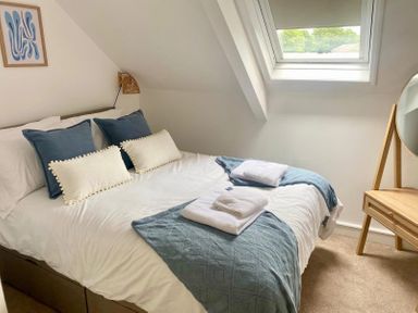 A bedroom with a bed and mirror at Central Tenby 3 Bed Apt Sleeps 6 to 8 Dog Friendly in Tenby