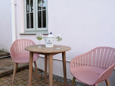A table with chairs and drinks at Yr Hen Beudy Barn Conversion Sleeps 4 Dogs Ok in Broadle Farm near Llansteffan