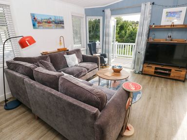 A living room with a sofa coffee table and television at Pleasant Valley Holiday Lodge 70 Stepaside