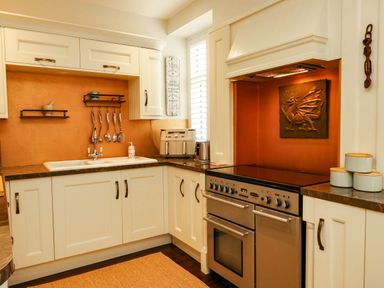 A kitchen with a sink, cooking range and utensils at 11 Bryn Goleu Avenue North Holyhead