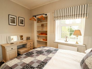 A bedroom with a bed, desk, and window at 11 Bryn Goleu Avenue North Holyhead