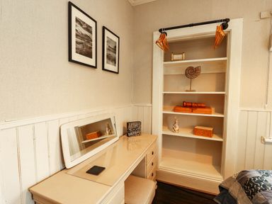 A bedroom with a desk and shelf at 11 Bryn Goleu Avenue North Holyhead