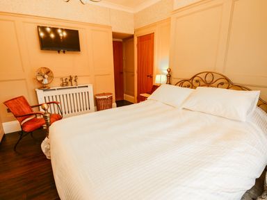 A bedroom with a bed and a chair at 11 Bryn Goleu Avenue North in Holyhead