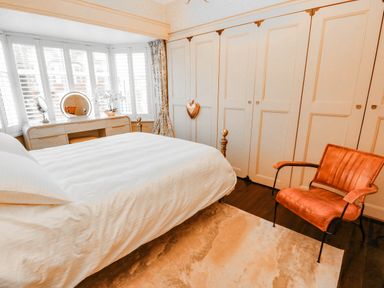 A bedroom with a bed, dresser, and chair at 11 Bryn Goleu Avenue North in Holyhead