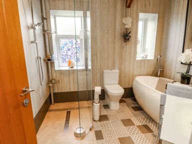 A bathroom with a shower, bathtub, and toilet at 11 Bryn Goleu Avenue North Holyhead