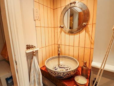 A bathroom with a decorative sink and mirror at 11 Bryn Goleu Avenue North Holyhead
