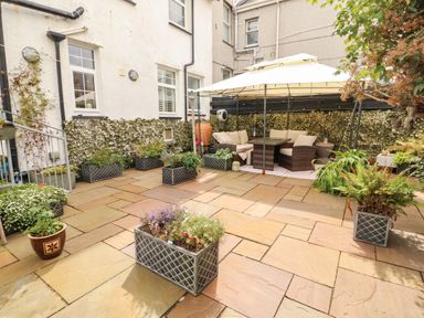 A garden with seating area and planters at 11 Bryn Goleu Avenue North Holyhead