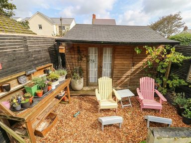 A garden with chairs and a shed at 11 Bryn Goleu Avenue North in Holyhead
