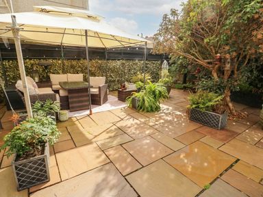 A garden with outdoor seating area and potted plants at 11 Bryn Goleu Avenue North Holyhead