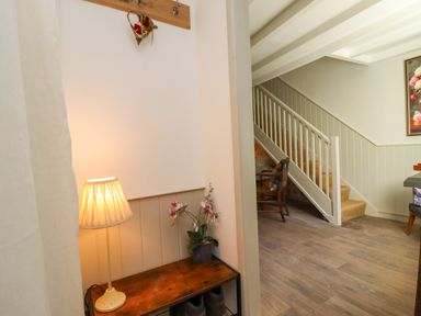 A hallway with a lamp and table at Blue Cottage in Malton