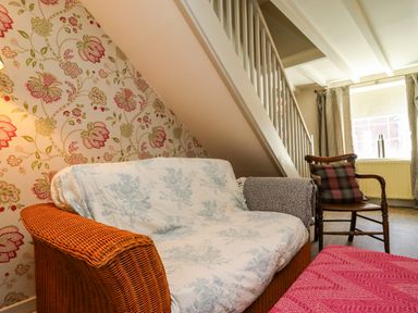 A living room with a sofa and armchair at Blue Cottage in Malton