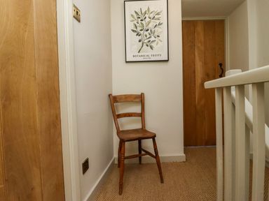 A hallway with a chair and an artwork at Blue Cottage in Malton