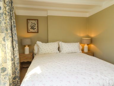 A bedroom with a bed and bedside table at Blue Cottage in Malton