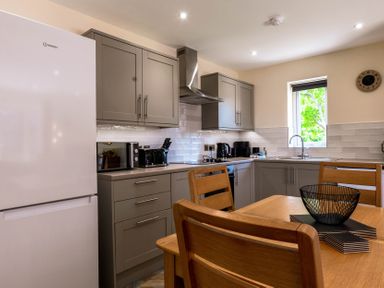 A kitchen with appliances and dining area at Bay Bungalow