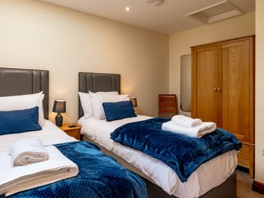A bedroom with two beds and a wardrobe at Bay Bungalow