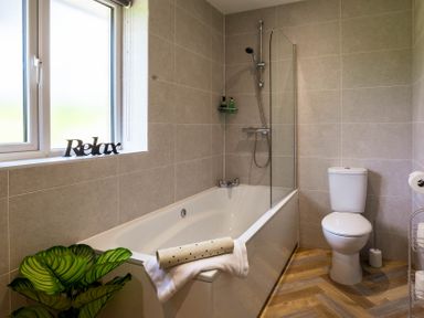 A bathroom with a bathtub and toilet at Bay Bungalow