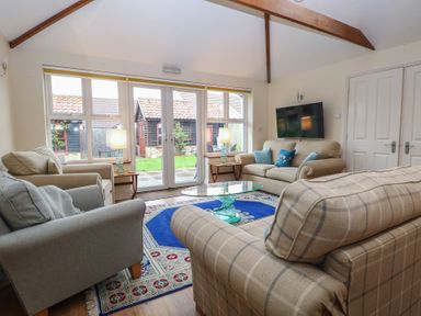 A living room with sofas and a coffee table at The Mill House Annexe Oulton Broad
