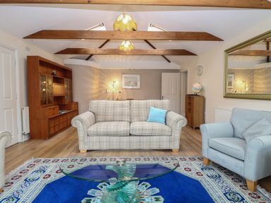 A living room with a sofa and coffee table at The Mill House Annexe Oulton Broad