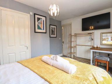 A bedroom with a bed and a television at The Mill House Annexe Oulton Broad