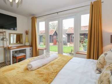 A bedroom with a bed and desk at The Mill House Annexe Oulton Broad