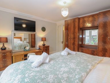 A bedroom with a bed and wardrobe at The Mill House Annexe in Oulton Broad