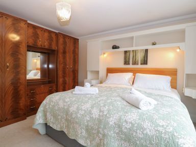 A bedroom with a bed and wardrobe at The Mill House Annexe Oulton Broad