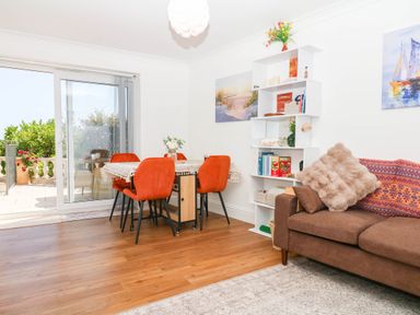 A dining room with a table and chairs at Elberry Cove View, Paignton