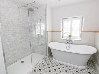 A bathroom with a shower and bathtub at Rheidiol in St Davids
