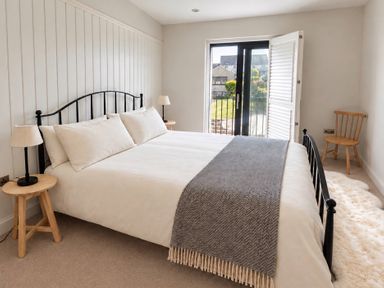 A bedroom with a bed and two bedside tables at Rheidiol in St Davids