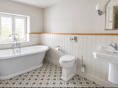 A bathroom with a bathtub, toilet, and sink at Rheidiol in St Davids