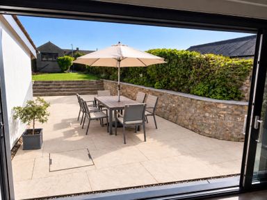A garden with a table and chairs under an umbrella at Rheidiol St Davids