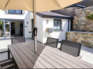 An outdoor dining area with a table and chairs at Rheidiol in St Davids