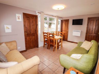 A living room with a table and chairs at Chalet 242 Carmarthen Bay in Kidwelly