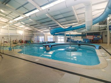 An indoor pool with a water slide and a lifeguard chair at Chalet 242 Carmarthen Bay Kidwelly
