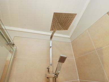 A showerhead and handheld shower in a bathroom at Fir Tree Lodge White Cross bay on Windermere Troutbeck Bridge
