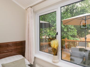 A bedroom with a window view at Fir Tree Lodge White Cross bay on Windermere Troutbeck Bridge