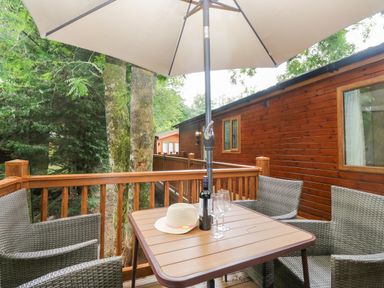 An outdoor seating area with a table and chairs at Fir Tree Lodge White Cross bay on Windermere, Troutbeck Bridge