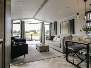 A living room with a sofa and dining table at Lakewood Plot 7 in Clacton-on-Sea