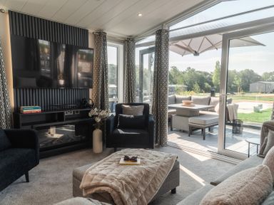 A living room with a television and seating at Lakewood Plot 7 St. Osyth