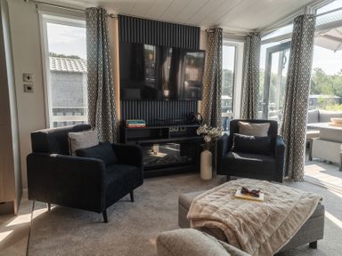 A living room with a television and seating area at Lakewood Plot 7 St. Osyth