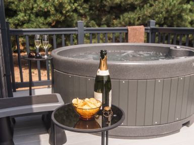 An outdoor area with a hot tub, champagne, and snacks at Lakewood Plot 7 St. Osyth