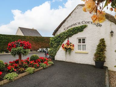 A garden with flowers and a cottage at Teresa's Cottage