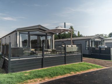 A park home with decking and furniture at Lakewood Plot 9 in St. Osyth