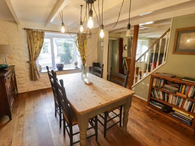 A dining room with a wooden table and chairs at Ty'r Wennol in Fishguard