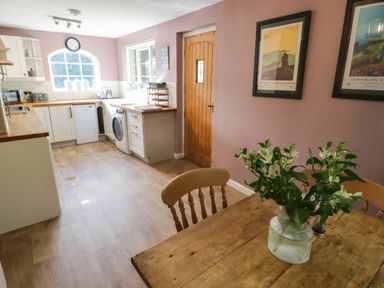 A kitchen with a table and chairs at Ty'r Wennol in Fishguard