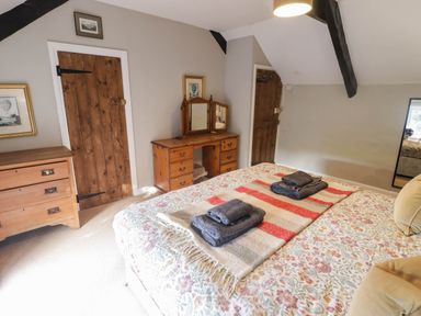 A bedroom with a bed and dressing table at Ty'r Wennol in Fishguard