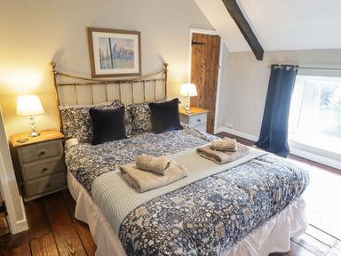 A bedroom with a bed and nightstand at Ty'r Wennol in Fishguard