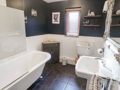 A bathroom with a bathtub and sink at Ty'r Wennol in Fishguard