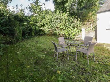 A garden with a table and chairs at Ty'r Wennol in Fishguard