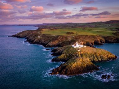 A lighthouse on an island surrounded by ocean at Ty'r Wennol in Fishguard